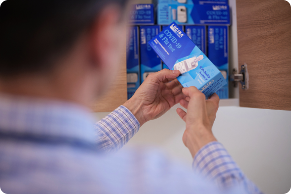 Person retrieving a LUCIRA® by Pfizer COVID-19 & Flu Test from a storage cupboard